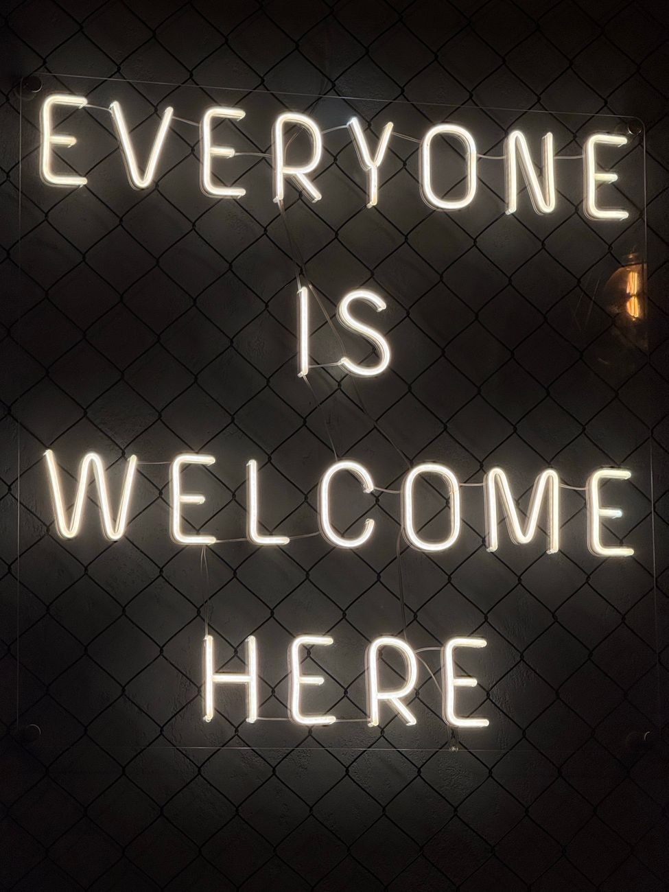 neon sign saying everyone is welcome here