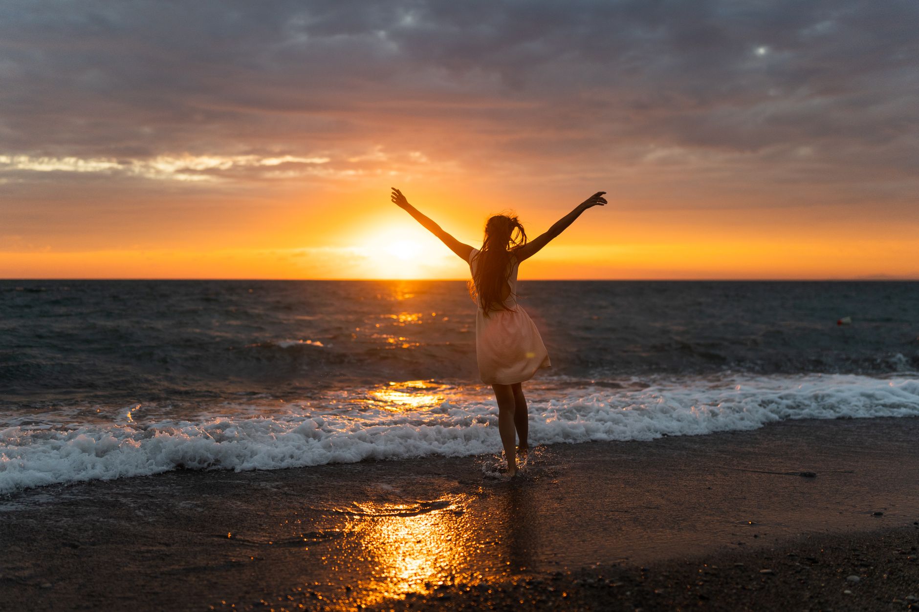 woman wearing a dress standing on the beach