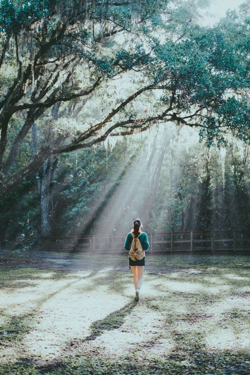 a woman standing under the tree